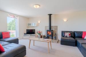 een woonkamer met een bank en een open haard bij Hill View Rise in Chipping Campden