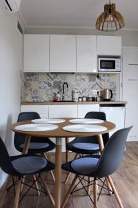 uma cozinha com uma mesa e cadeiras numa cozinha em Domek Nad Zalewem em Goldap