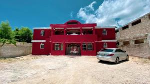 a red building with a car parked in front of it at Hotel Punto4 in Punta Cana