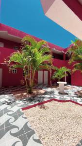 a red building with palm trees in front of it at Hotel Punto4 in Punta Cana
