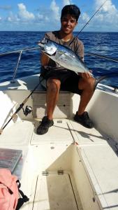 Un uomo seduto su una barca con un pesce di Tiny House RV, Kayak a Key Largo