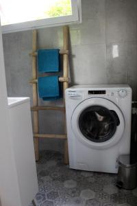 uma máquina de lavar roupa numa pequena casa de banho com uma janela em Domek Nad Zalewem em Goldap