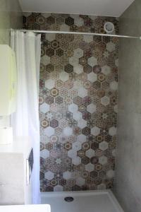 uma cortina de chuveiro na casa de banho com uma parede em azulejo em Domek Nad Zalewem em Goldap