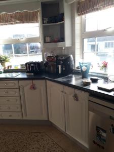 a kitchen with white cabinets and black counter tops at Oakland in Portadown