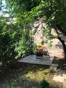 a table and chairs sitting on a patio under a tree at Urban CITY in Olecko