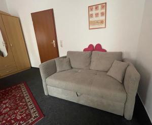 ein Wohnzimmer mit einer Couch mit einer roten Schleife darauf in der Unterkunft Ferienwohnung NEUMANN a.d. Porzellan-Manufaktur in Meißen