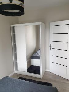 sypialnia z lustrem w rogu pokoju w obiekcie Apartament Słoneczny Taras w Kołobrzegu