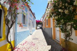 um beco com flores no lado dos edifícios em Casa Dom Carlos em Ferragudo