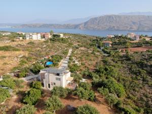 an aerial view of a house on a hill next to the water at Ktima Nikolaos in Arónion