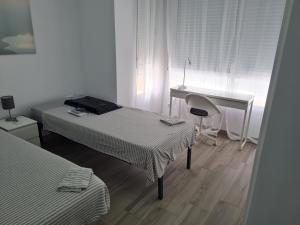 アリカンテにあるMini apartamentの白い部屋(ベッド2台、デスク付)