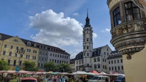 una ciudad con una torre de reloj con una multitud de personas en KLASSIK Design-Luxus-Apartment, Nahe Marktplatz, en Gera