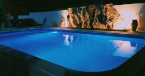 una grande piscina con illuminazione blu in una casa di Orange Paradise b&b a Custonaci