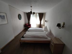 a bedroom with two beds and a window at Hotel Restaurant Jungfrau in Lauterbrunnen