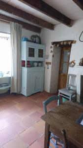 a living room with a table and a kitchen at Fig Tree Barn in Gibourne