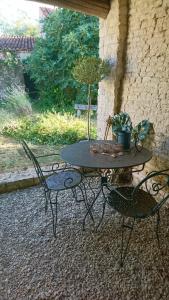 een terrastafel met twee stoelen en een potplant erop bij Fig Tree Barn in Gibourne