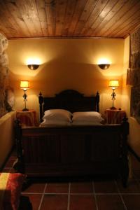 Casa Aido Santo في Pinheiro de Lafões: غرفة نوم مع سرير مع مصباحين على طاولتين