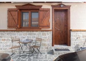 patio con mesa, sillas y puerta de madera en Bosporus Apartments, en Sarti