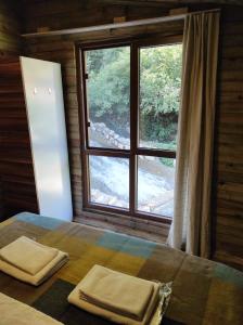 1 dormitorio con 1 cama con ventana y 2 toallas en Kure Dag Evi en Ulus