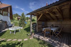 patio ze stołem i krzesłami na podwórku w obiekcie Haus Belodei - Apt A w mieście San Martino in Badia