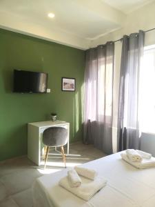 a bedroom with a bed and a tv on a green wall at ISTAI Cagliari City Center Rooms in Cagliari