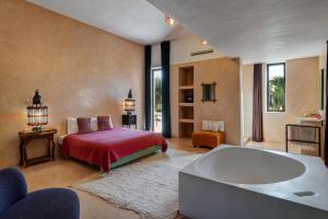 sypialnia z łóżkiem i wanną w obiekcie Pavillon Terra Ababila en Exclusivité w Marakeszu