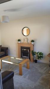 a living room with a coffee table and a fireplace at No2 Glan Nodwydd in Pentraeth