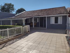 a house with a white fence and a patio at Casa de Férias in Florianópolis