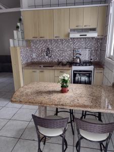 a kitchen with a large marble table and chairs at Casa de Férias in Florianópolis +6 photos