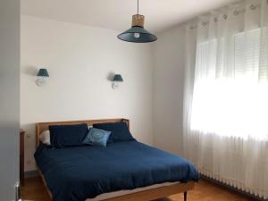 Coalpie في Barbaste: غرفة نوم بسرير ازرق ونافذة