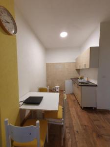 a kitchen with a table and a clock on a wall at Apartmani Sarti Banja Luka in Banja Luka