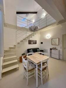 a dining room with a table and a staircase at Senigallia Loft La ContEsSa in Senigallia