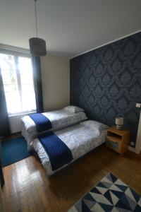 a bedroom with a bed with a blue wall at Maison du Verger in Le Vigeant