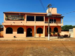 ein Hotel mit einem Schild an der Seite eines Gebäudes in der Unterkunft Hotel Tropical in Aquidauana
