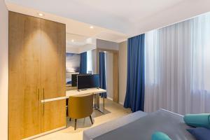 a bedroom with a bed and a desk with a computer at Ribarska Koliba Resort in Pula
