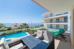 a balcony with a table and chairs and a swimming pool at Porto de Mós 72 by Destination Algarve in Porto de Mós