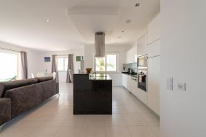 a living room with a couch and a kitchen at Porto de Mós 72 by Destination Algarve in Porto de Mós