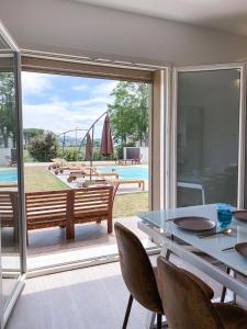 una sala da pranzo con tavolo e vista sulla piscina di Villa Felice a San Giovanni in Marignano