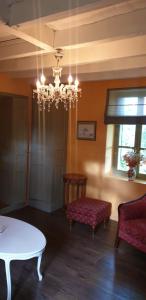 ein Wohnzimmer mit einem Tisch und einem Kronleuchter in der Unterkunft Maison Fleurie in Coulonges