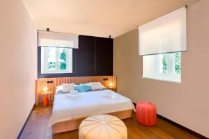 a bedroom with a large bed with two windows at Ribarska Koliba Resort in Pula