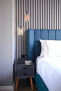 a bed with a blue headboard and a night stand with a phone at HOTEL BRONTE in Istanbul