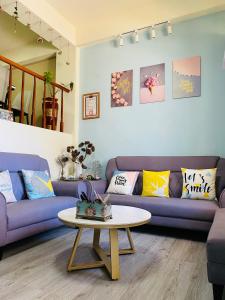 a living room with purple couches and a coffee table at Er Jie's House in Jinning