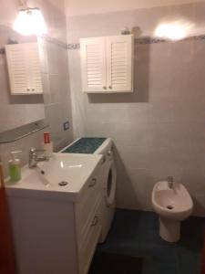 ラヴァーニャにあるLa casa nel verdeの洗面台とトイレを備えた白いバスルーム