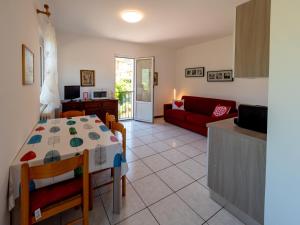a living room with a table and a red couch at Veroalex in Abbadia Lariana
