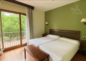 a bedroom with two beds and a balcony at Hotel Bufon de Arenillas in Vidiago
