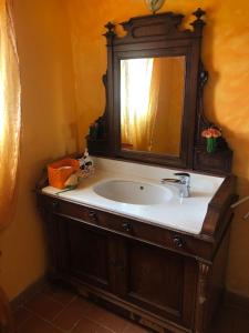 La salle de bains est pourvue d'un lavabo et d'un miroir. dans l'établissement Monolocale La Mimosa, à Elmo