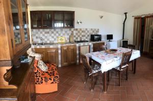 une cuisine avec une table et des chaises dans l'établissement Monolocale La Mimosa, à Elmo