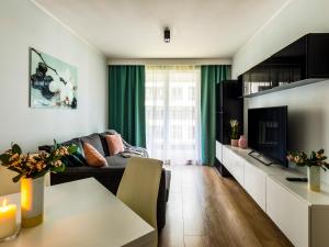 a living room with a couch and a tv at Jack II Apartment in Kraków