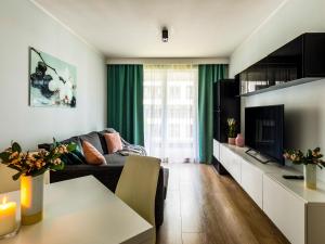 - un salon avec un canapé et une télévision dans l'établissement Jack II Apartment, à Cracovie