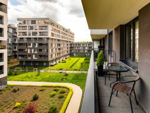 a balcony with a table and chairs and a green field at Jack II Apartment in Kraków