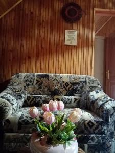 sala de estar con sofá y mesa con flores en Erdei Szalonka Vendégház, en Háromhuta